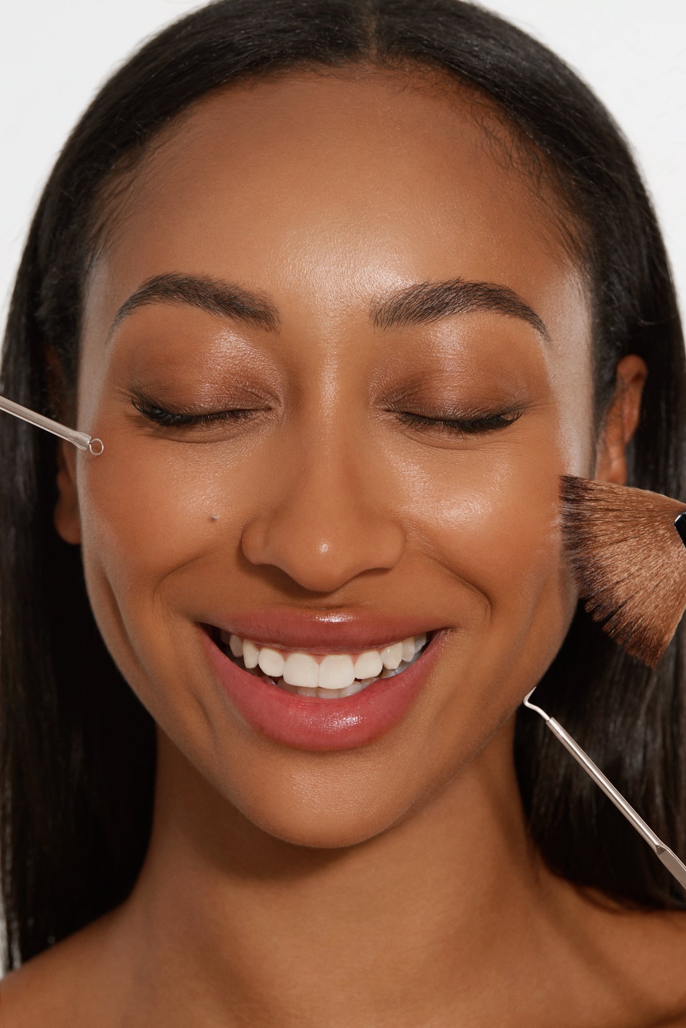 Close-up of a woman’s smiling face with different facial care tools, showcasing various skincare treatments and the confidence boost from effective facial care.